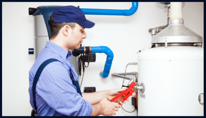 Plumber performing hot water system maintenance with tools in a Canberra home.