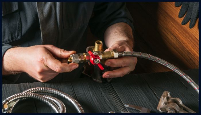 Close-up of plumber repairing pipe fittings to highlight the value of regular plumbing maintenance in Canberra homes.