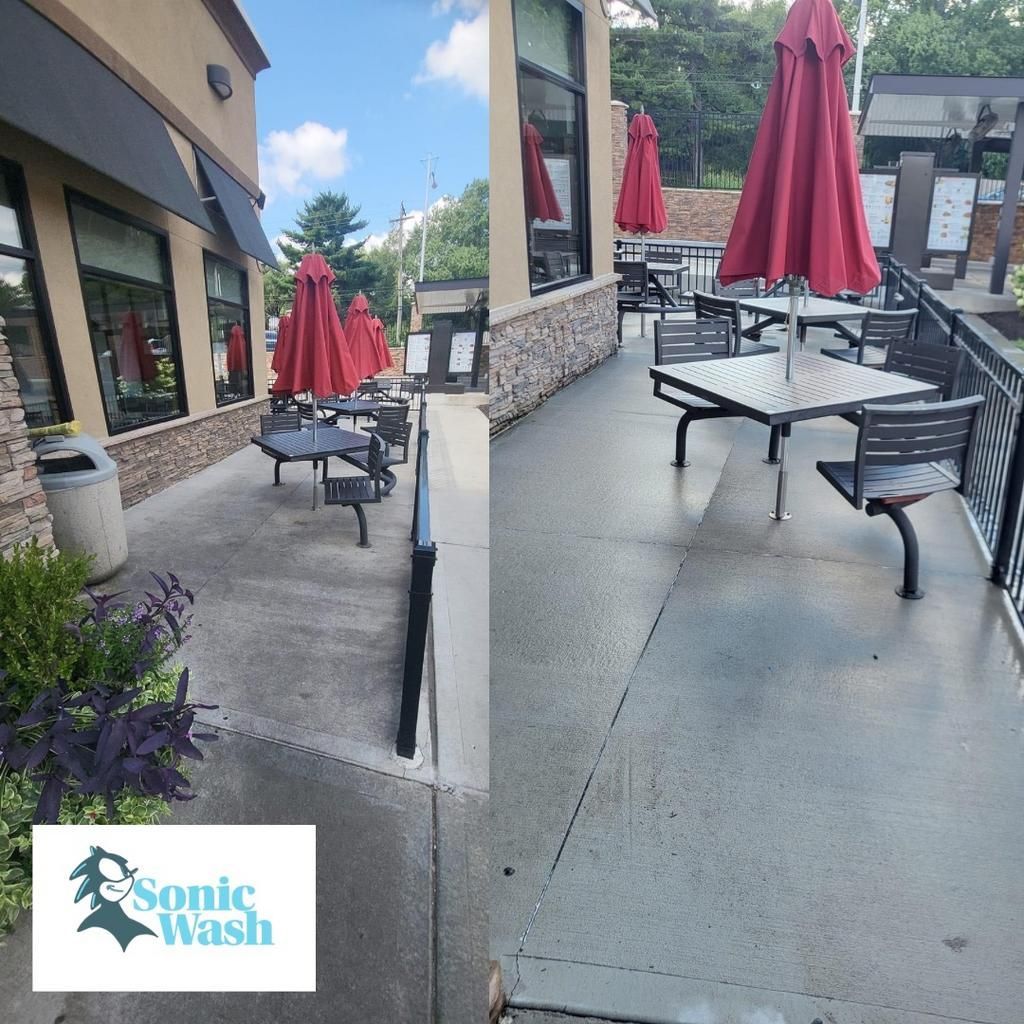 A patio with tables and chairs and red umbrellas