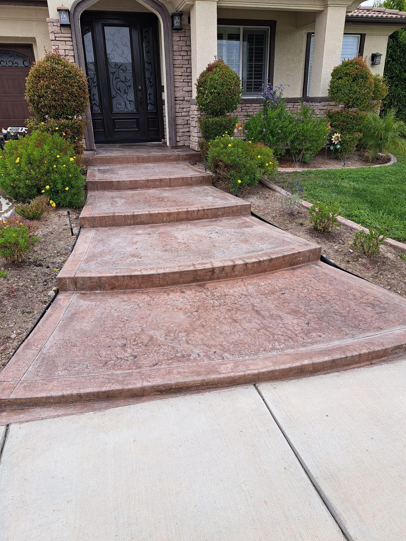 A concrete walkway leading to the front door of a house.