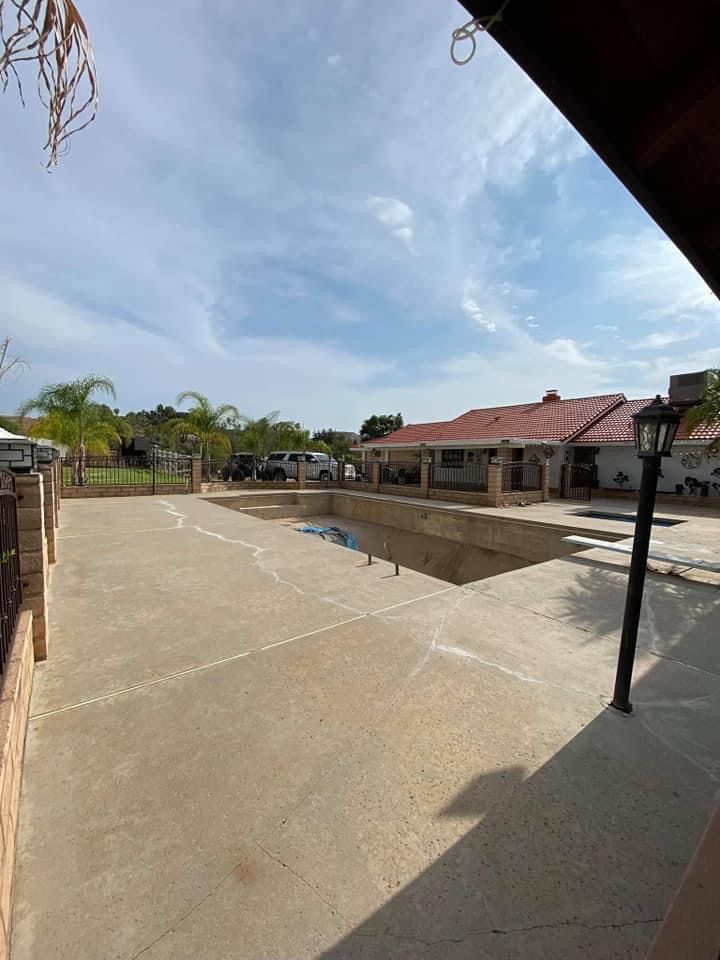 A swimming pool is being built in the backyard of a house.