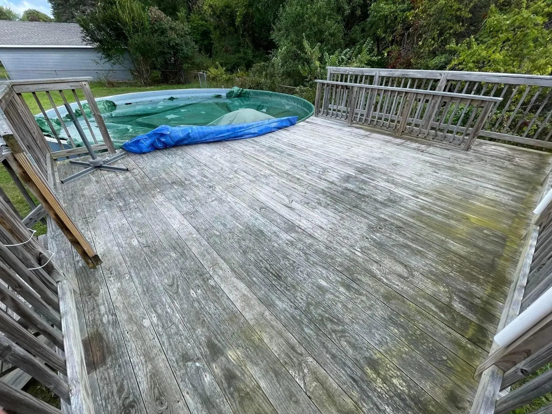 A wooden deck with a hot tub in the background.