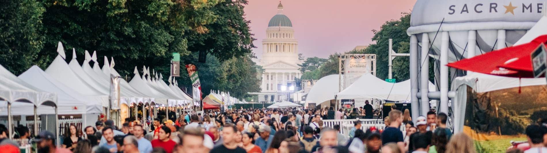 A large crowd of people are gathered at a festival.