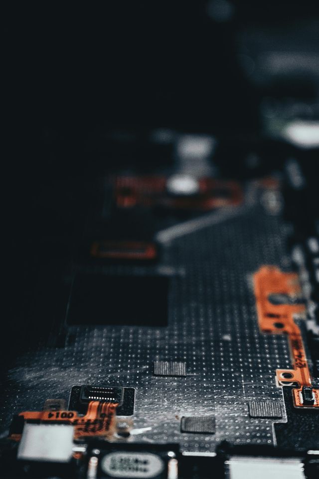 Close-up of a circuit board with tiny components in varying shades of gray, black, and orange.