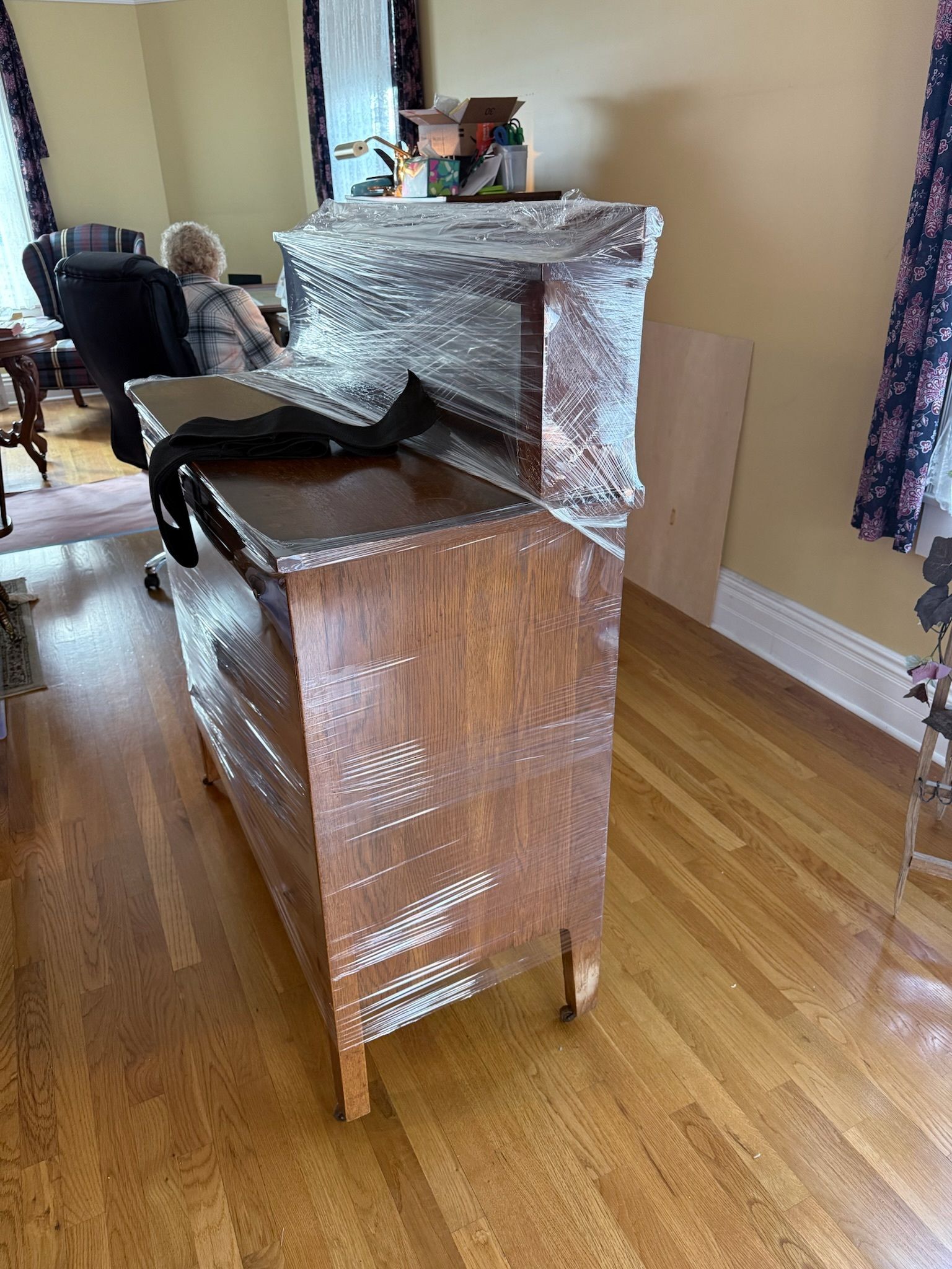 Office being moved: Desk with computer, chairs wrapped, boxes, under staircase.