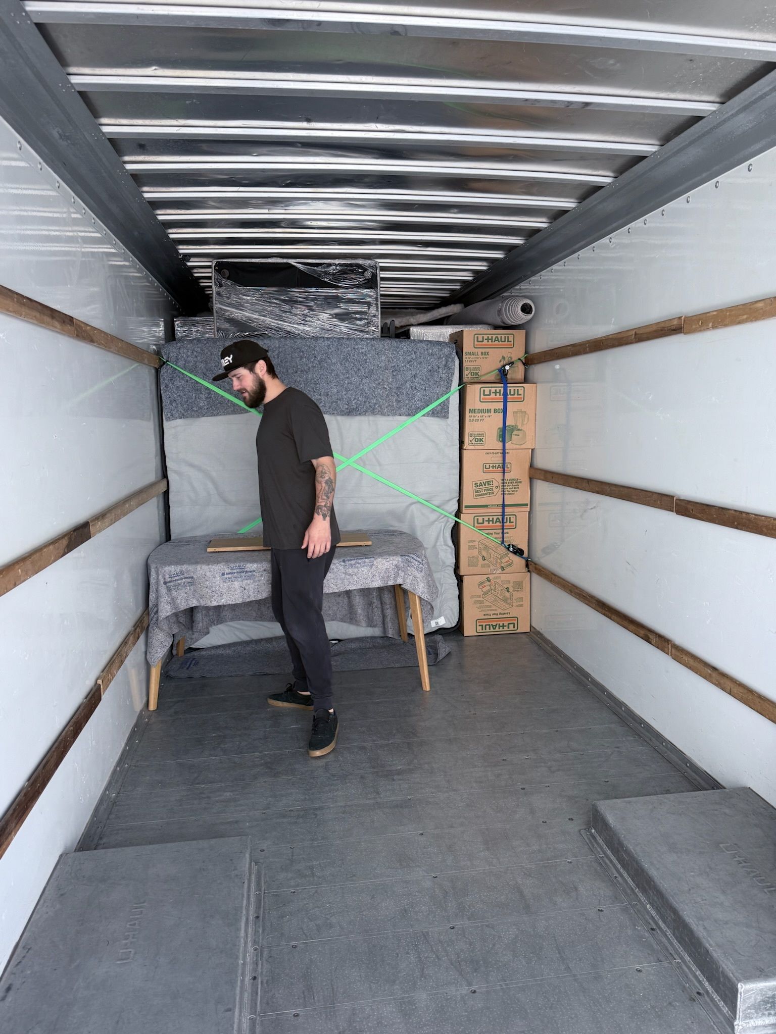 Kitchen with cardboard boxes, cabinets, and appliances, indicating a move.