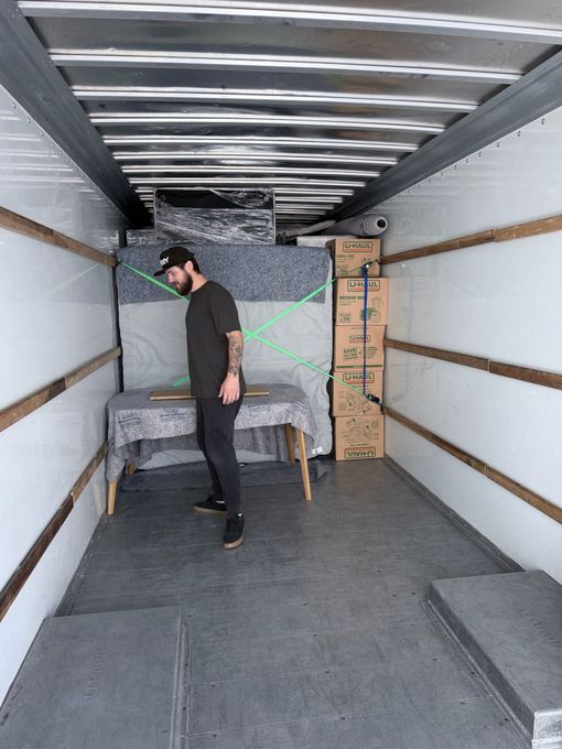 Kitchen with cardboard boxes, cabinets, and appliances, indicating a move.