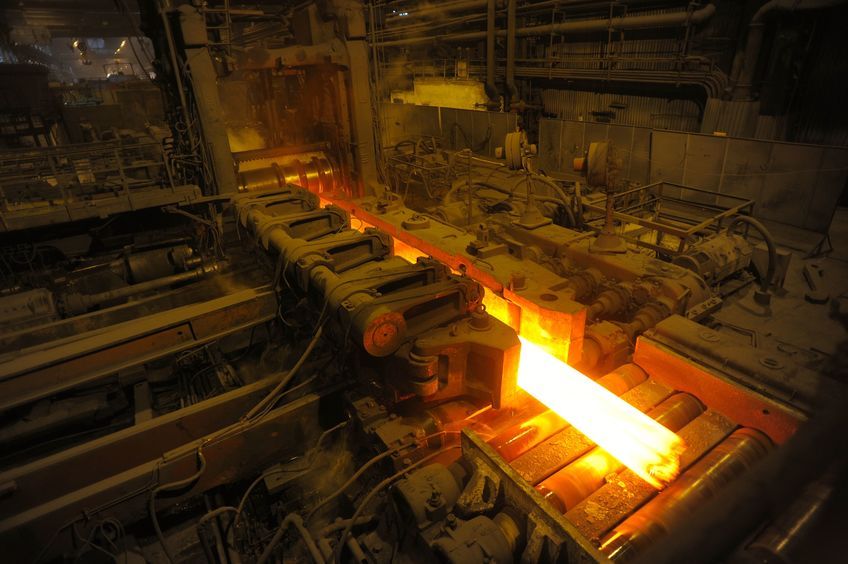 A glowing hot bar of steel in a factory.