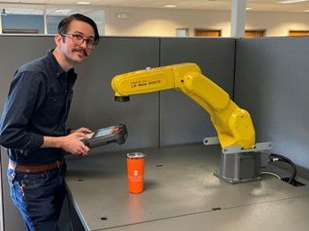 Doug working with a robotic arm in the office.