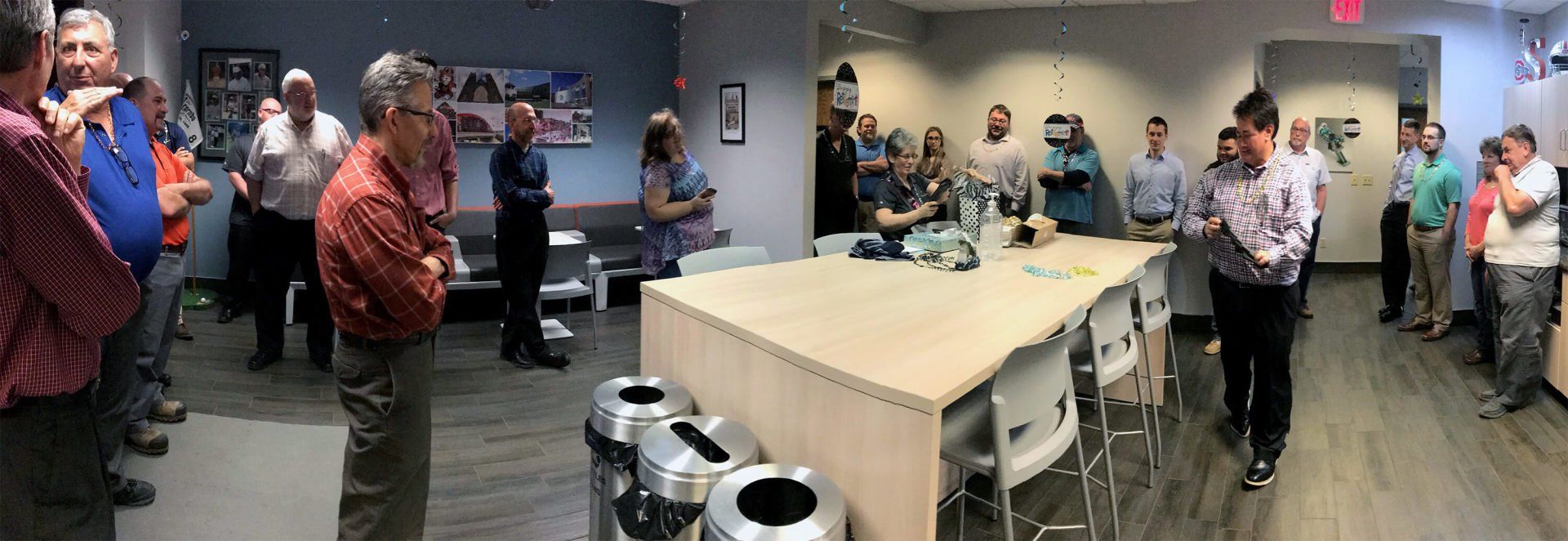 Grazyna opening a box on a table. Seifert employees are around her