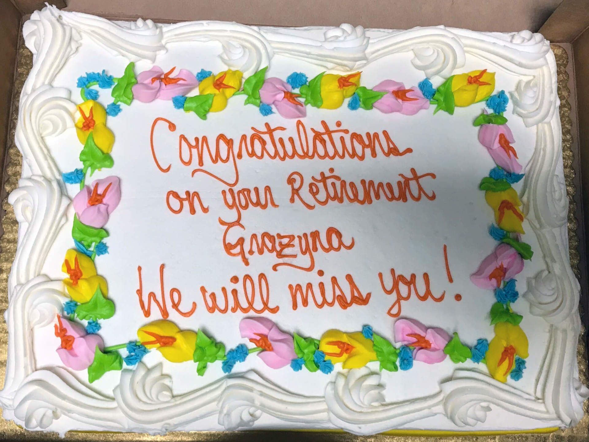 A cake. The frosting makes a border of flowers. The text says 