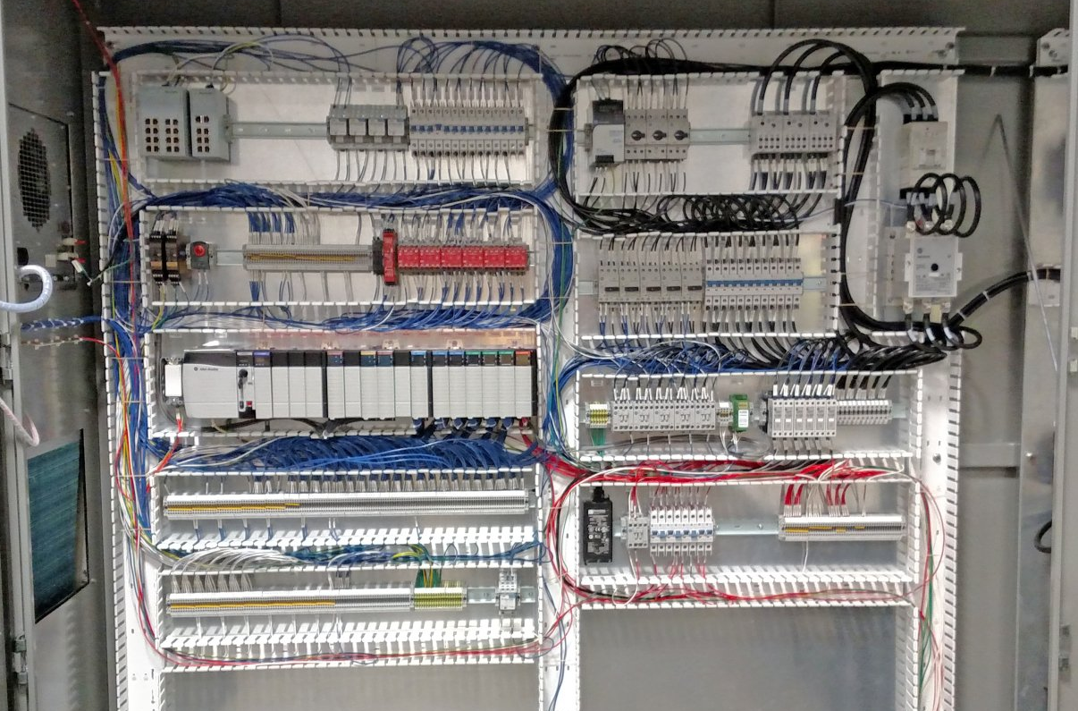 PLC panel with many components and organized wires.