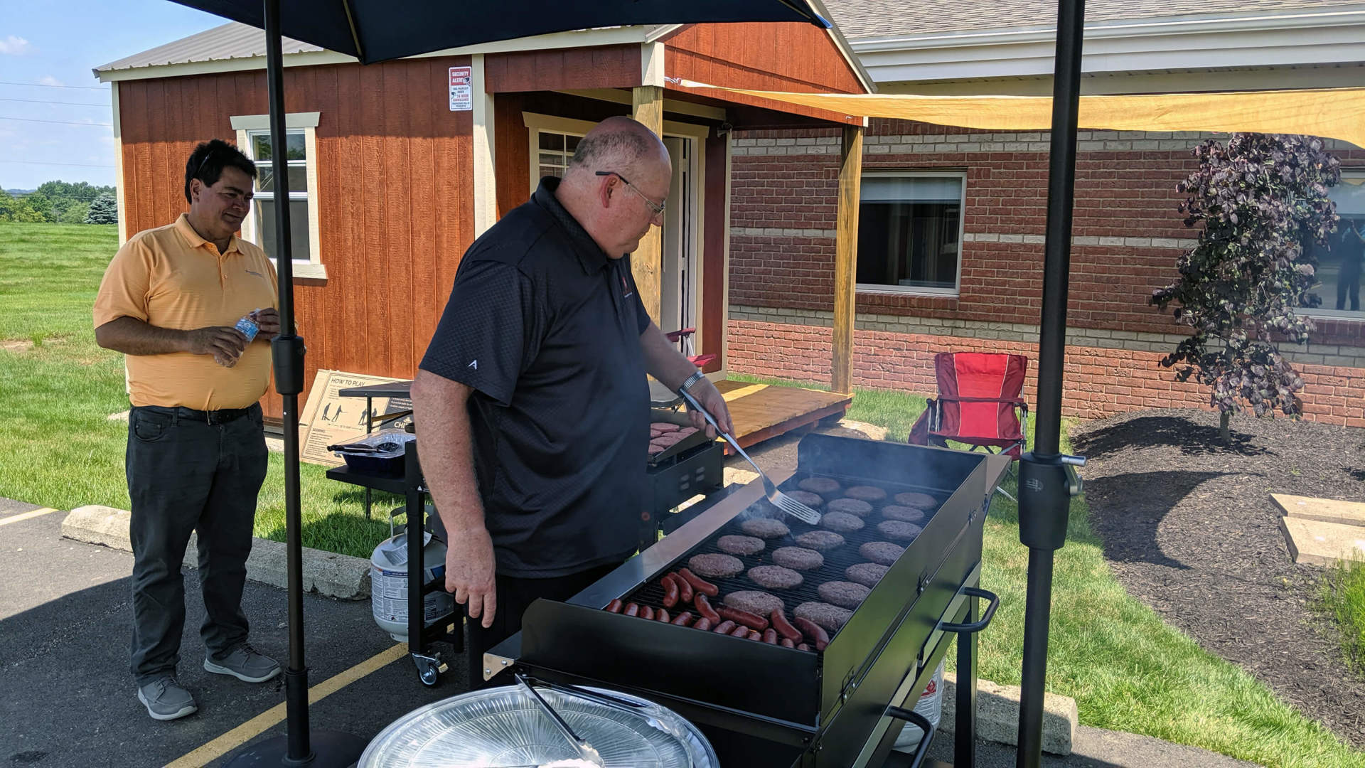 An employee at the grill, another is behind him