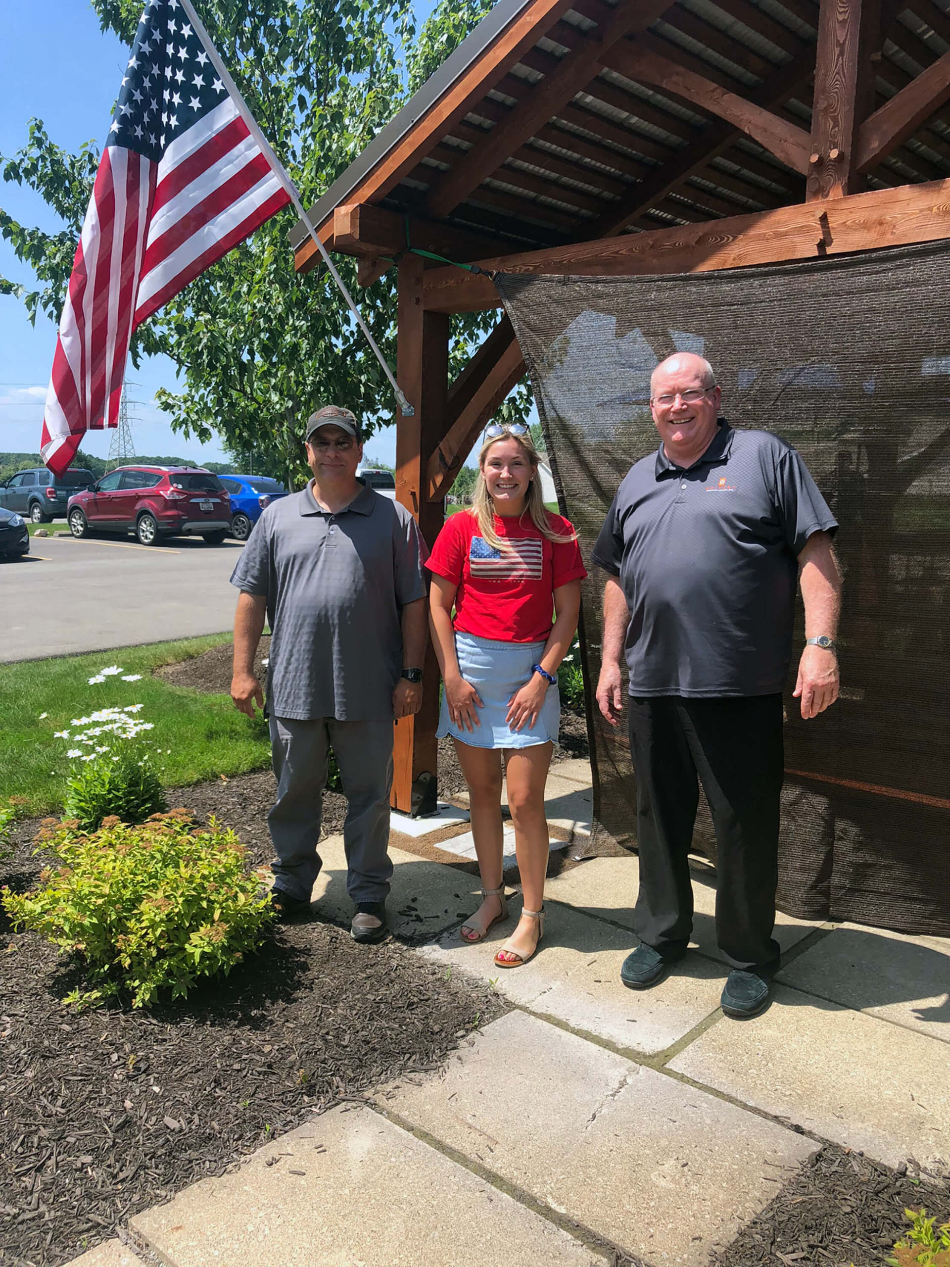 Three employees under the pavilion, smiling