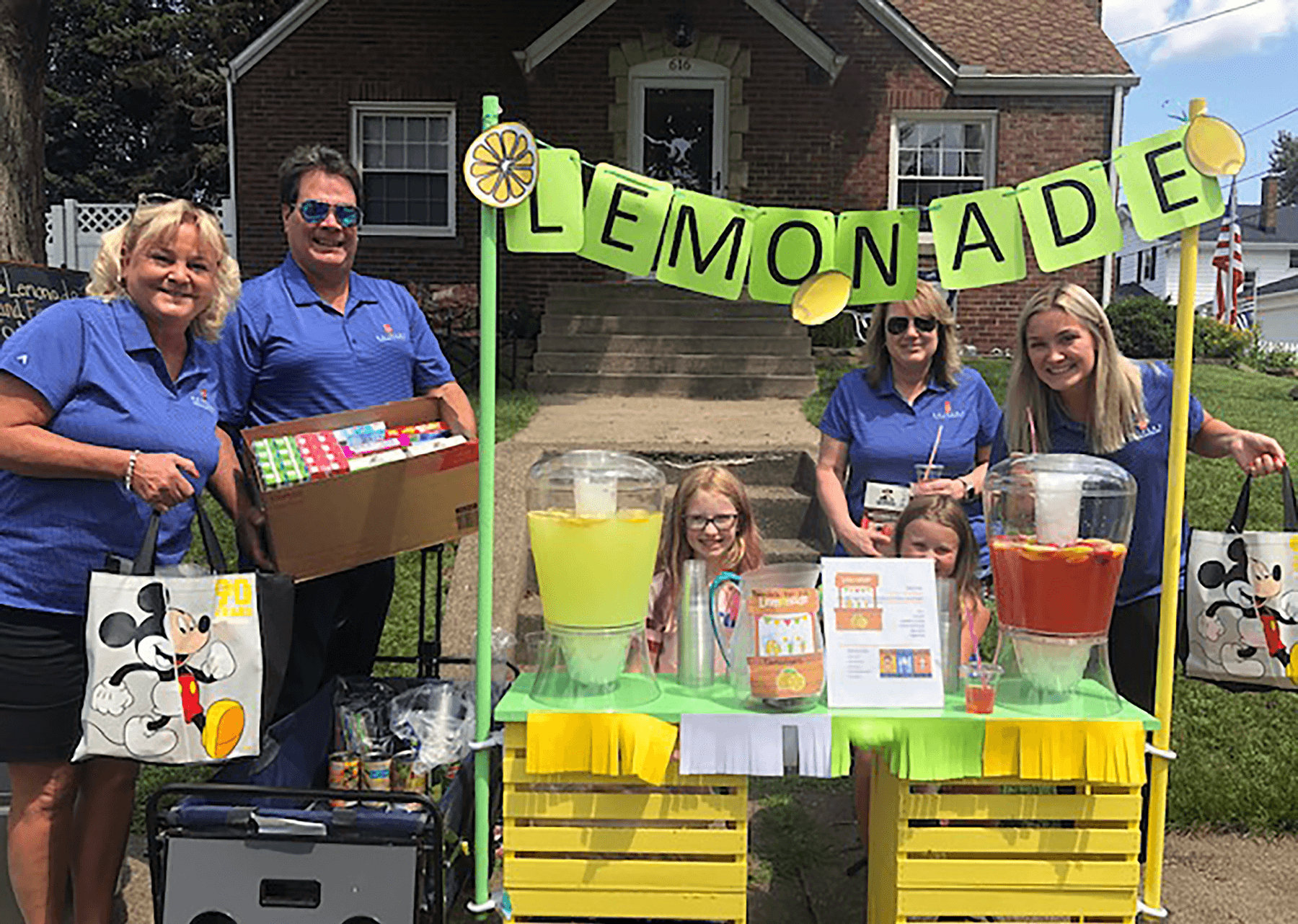 Four Seifert employees and two children at a lemonade stand.