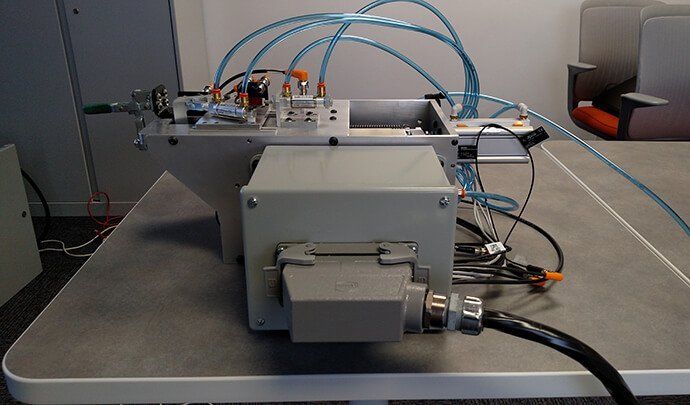 A manufactured controls box placed on a table. There are tubes running out of the box.