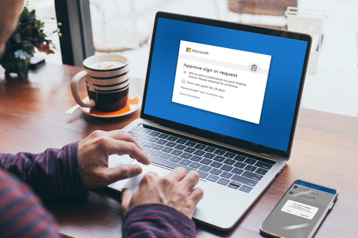 A person at a laptop with a sign in request prompt on the screen