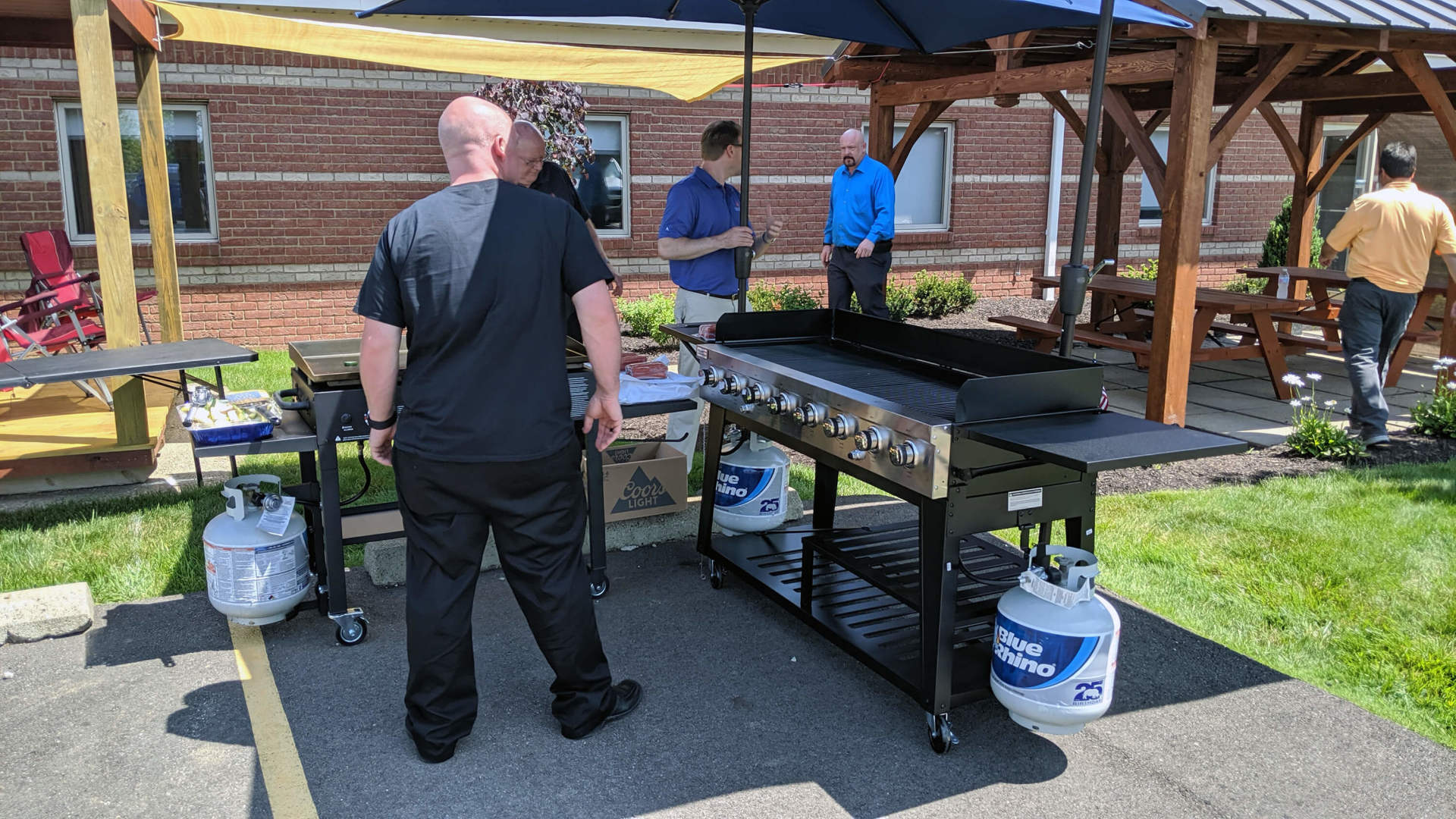 Five employees around the company grill