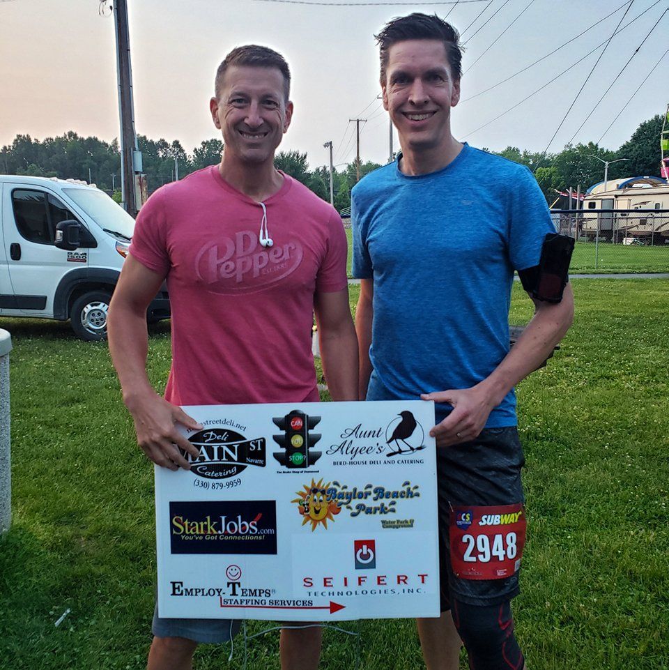 Carl Maxfield and Doug Hill holding a sign.