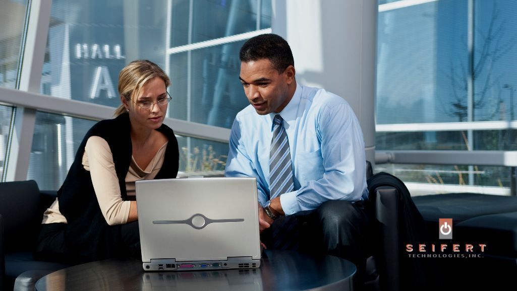 Two people looking over a computer with integrated systems