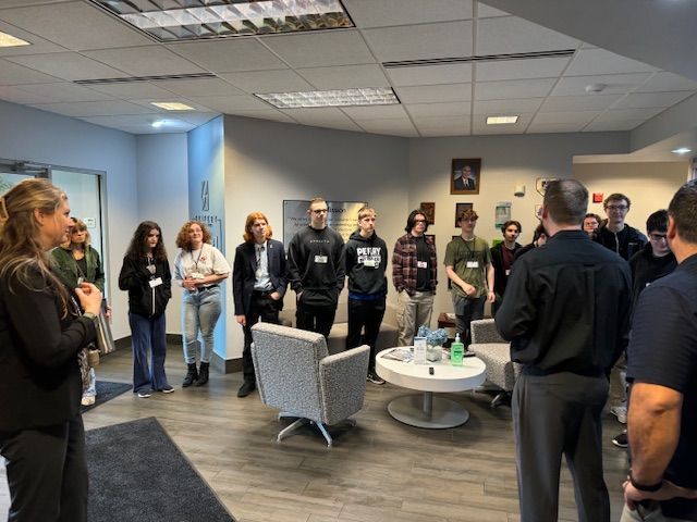 Students arranged in a circle. Seifert employees are giving a talk.