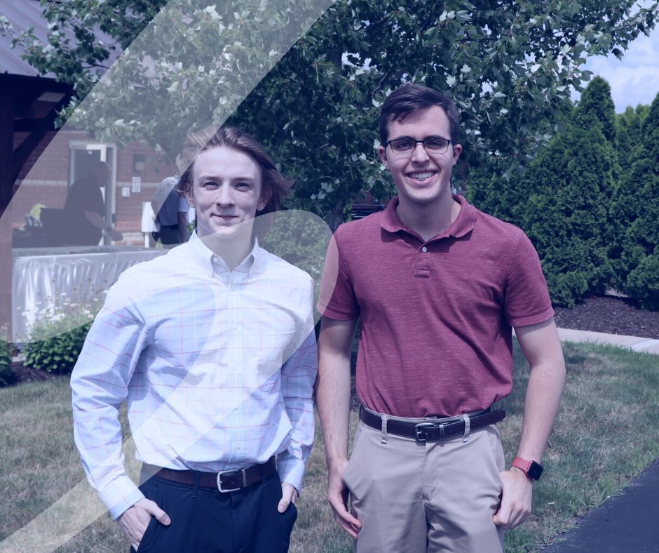 Two summer interns smiling outside.