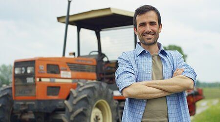 Farmer in front of tractor — Farming supplies & farming machinery in mackay