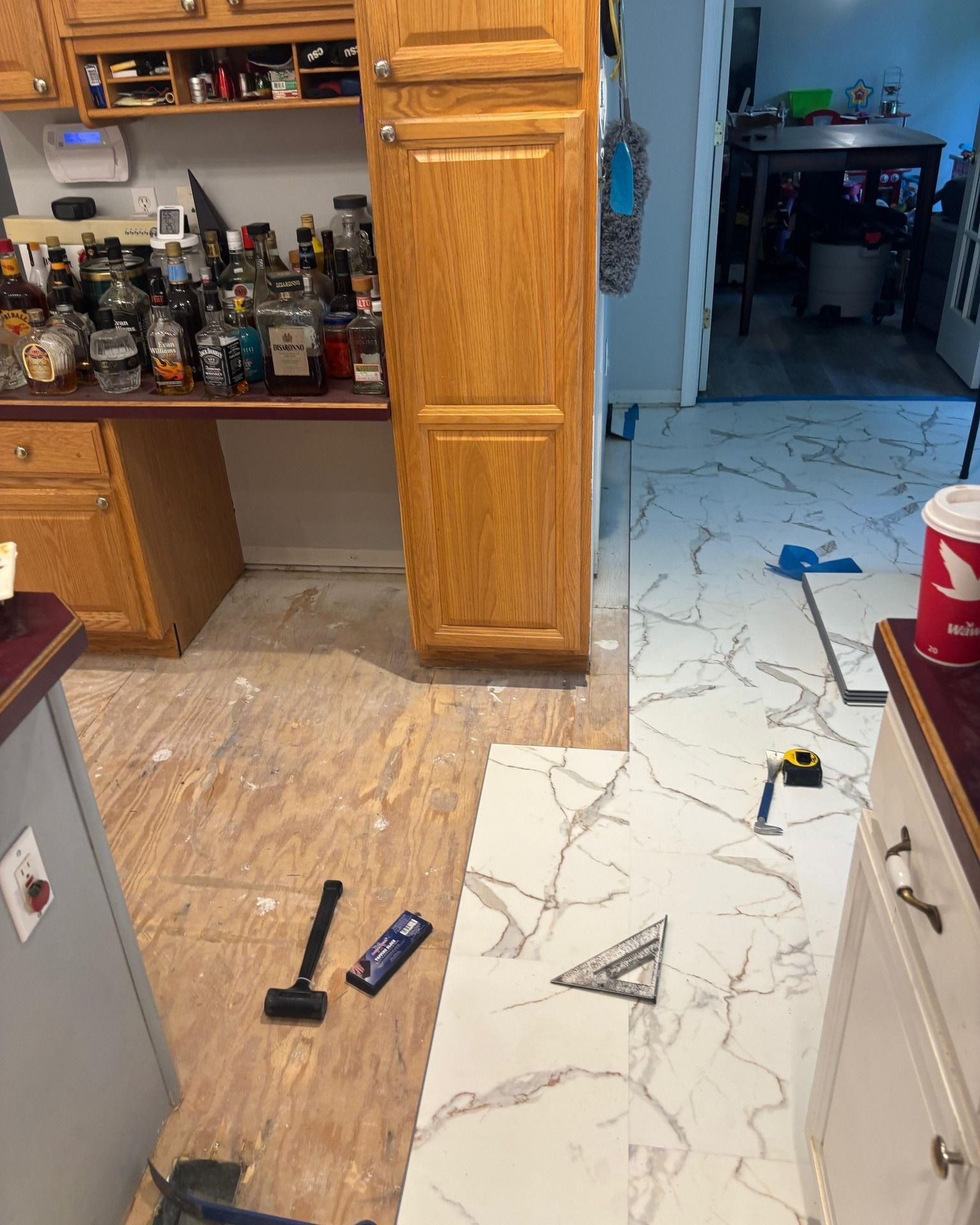 Woman in straw hat smiles, holding wine glass near a lake.