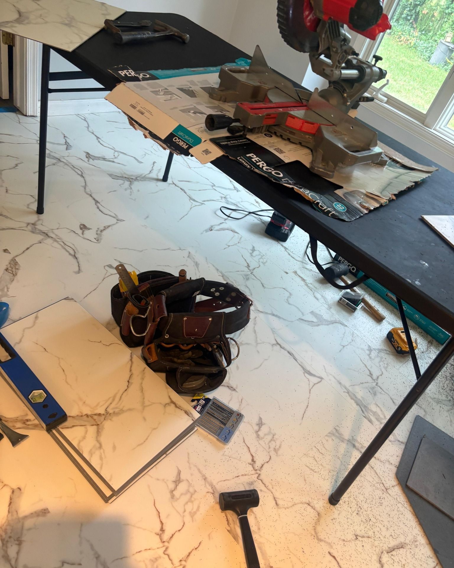 Woman in straw hat smiles, holding wine glass near a lake.