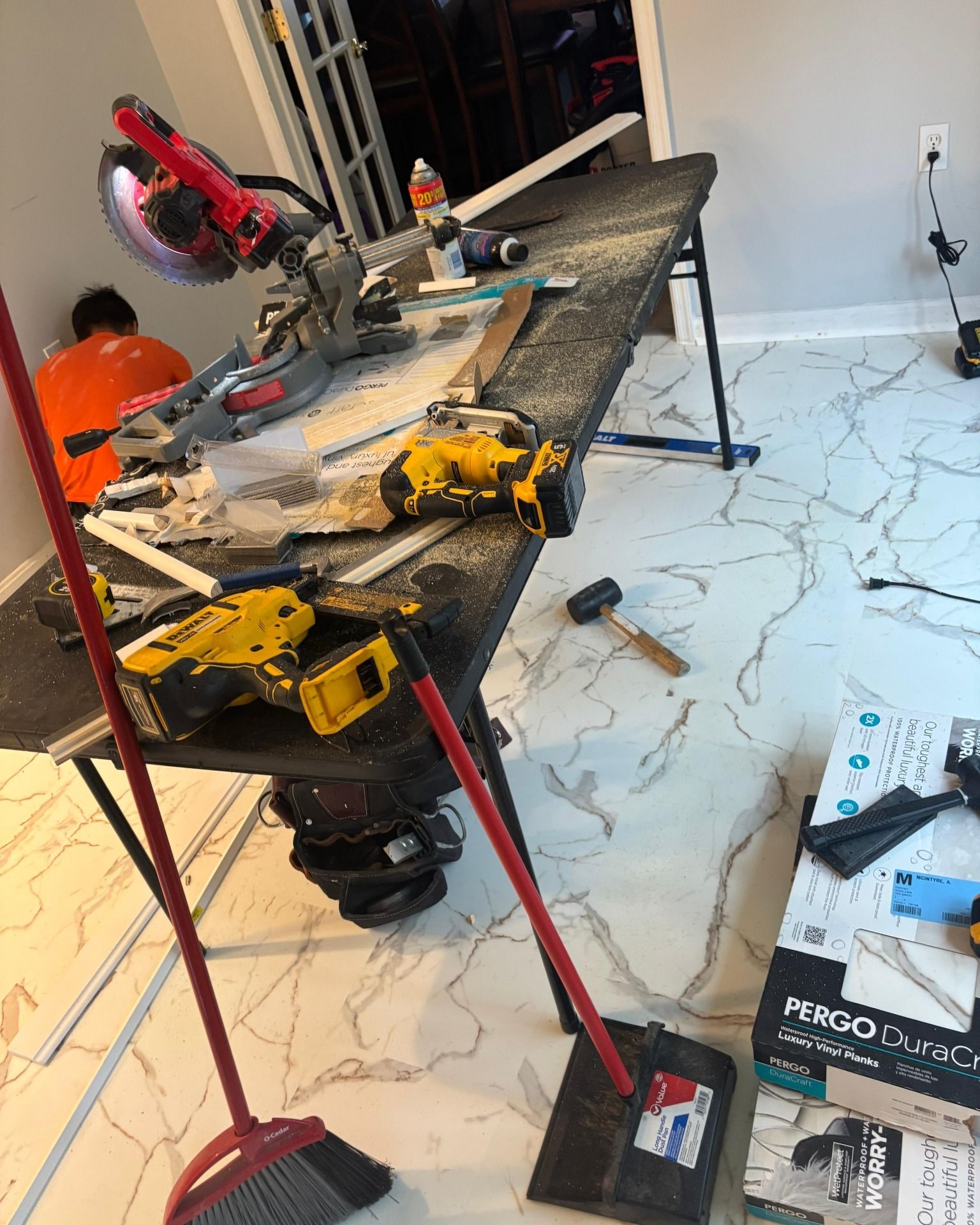 Woman in straw hat smiles, holding wine glass near a lake.