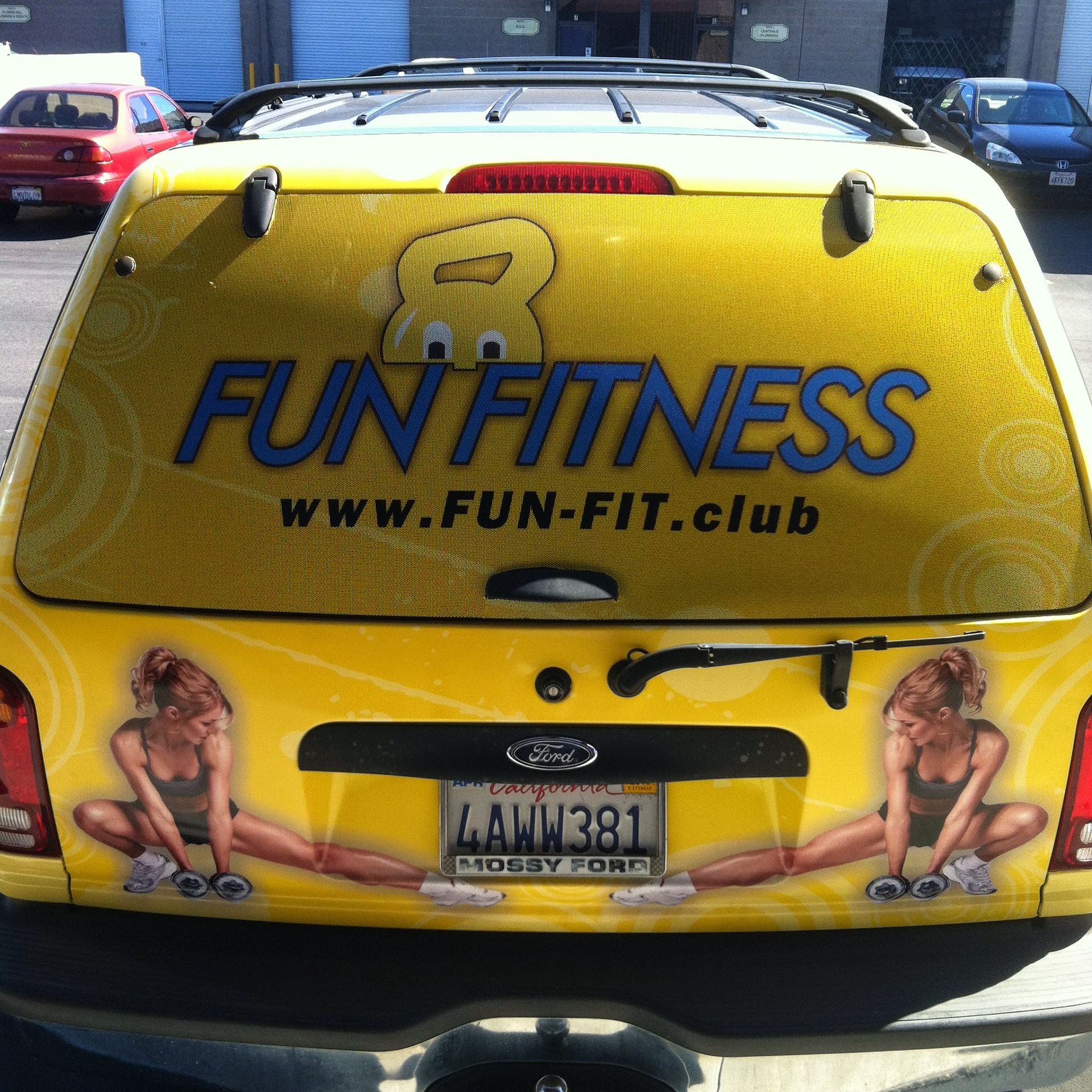 Yellow SUV promoting Fun Fitness with logo, website, and illustrations of women exercising.