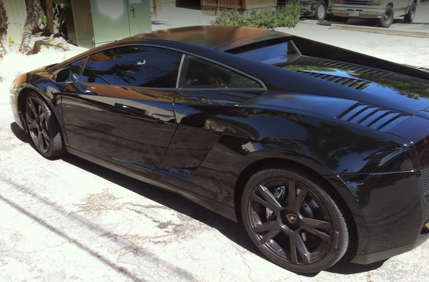 Black Lamborghini parked on a street.