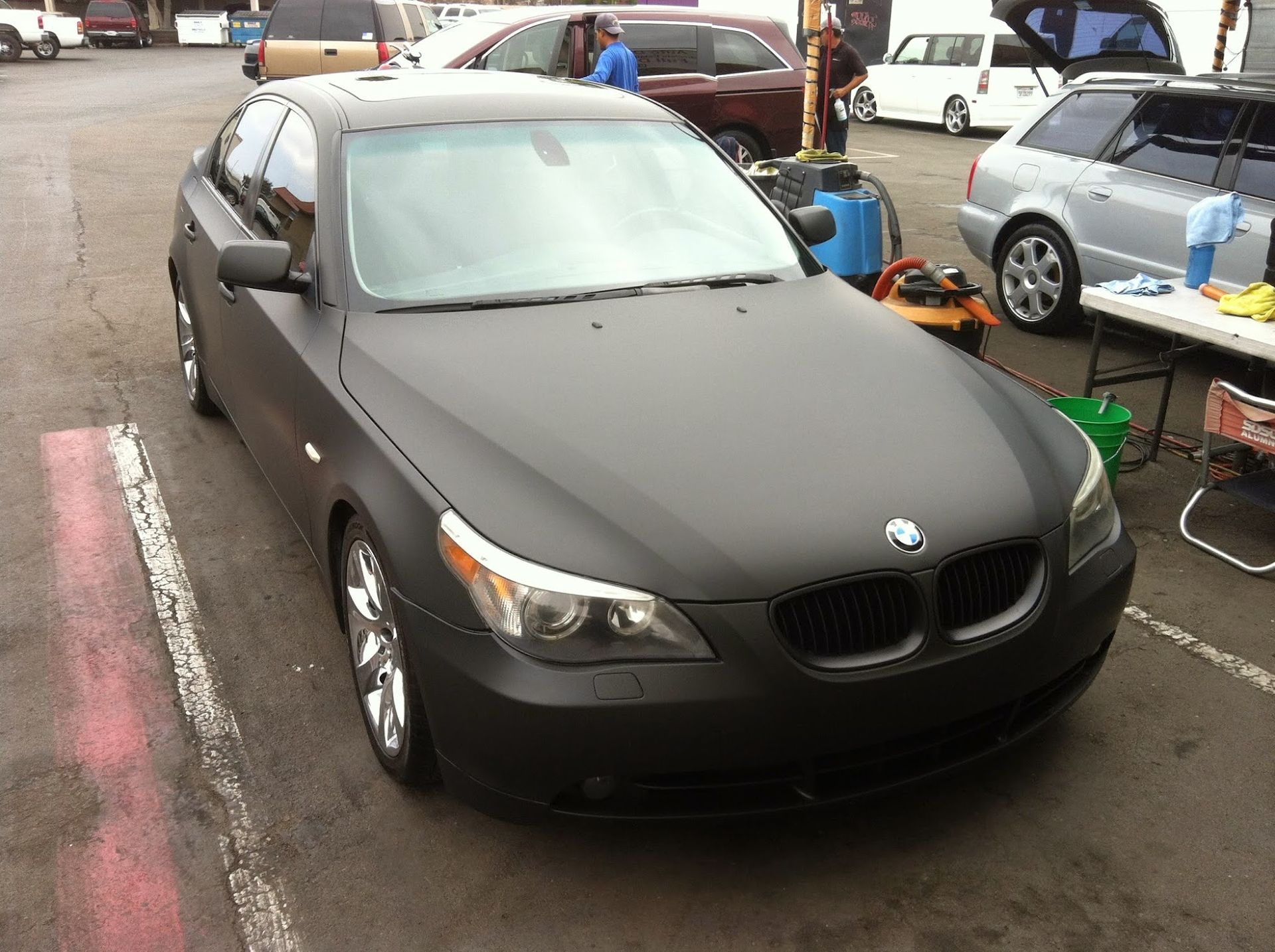 Black matte BMW sedan parked in an outdoor lot.