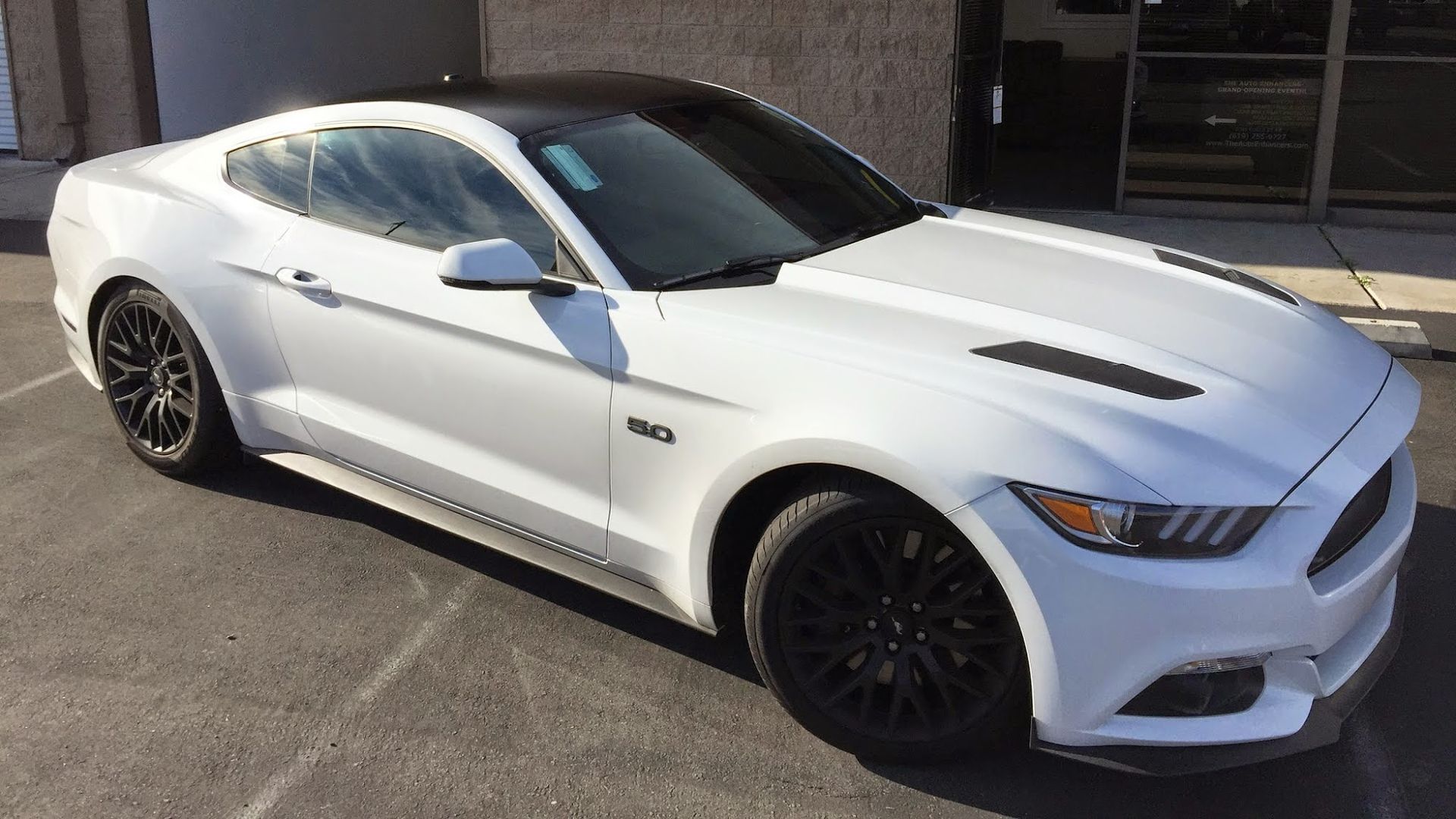 White Ford Mustang with black wheels and roof.