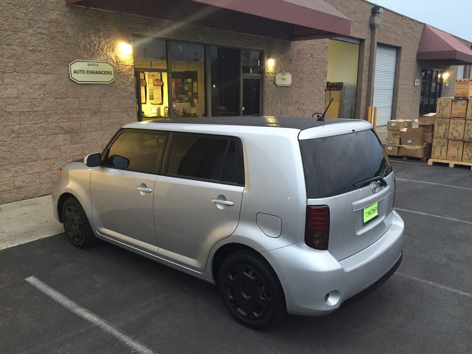 Silver Scion xB parked outside a building. Black wheels, tinted windows.