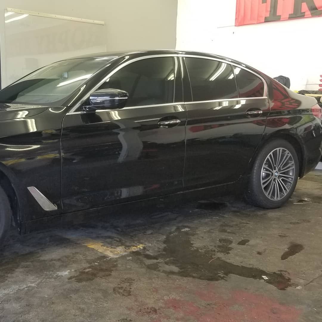 Black sedan with tinted windows parked in a garage.