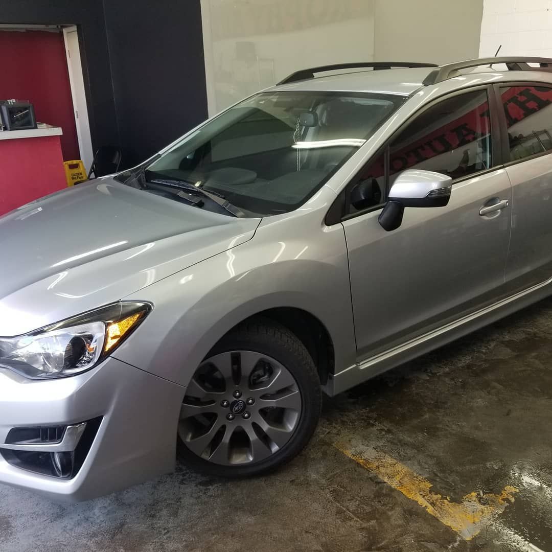 Silver Subaru Impreza wagon parked inside a garage.