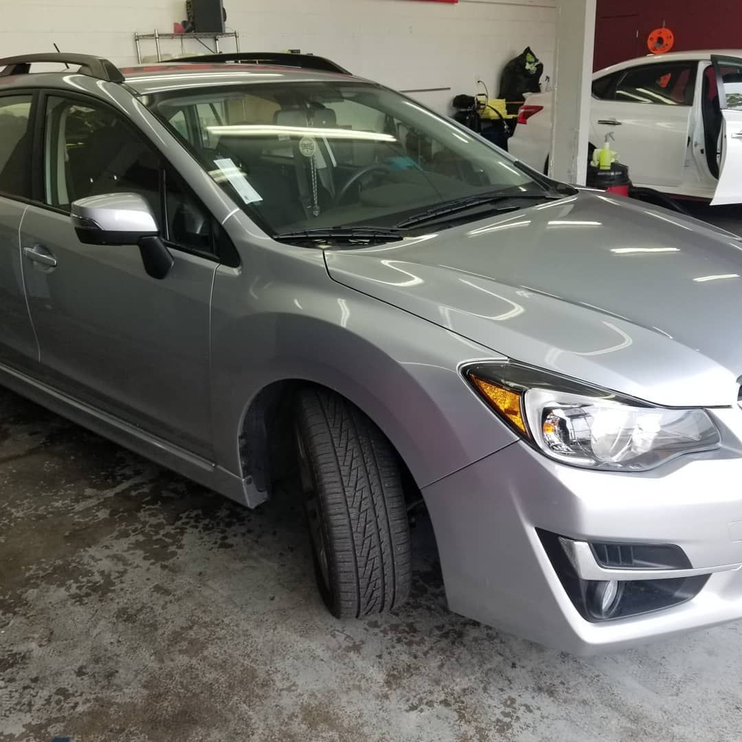 Silver Subaru Impreza parked inside a garage with another car in the background.