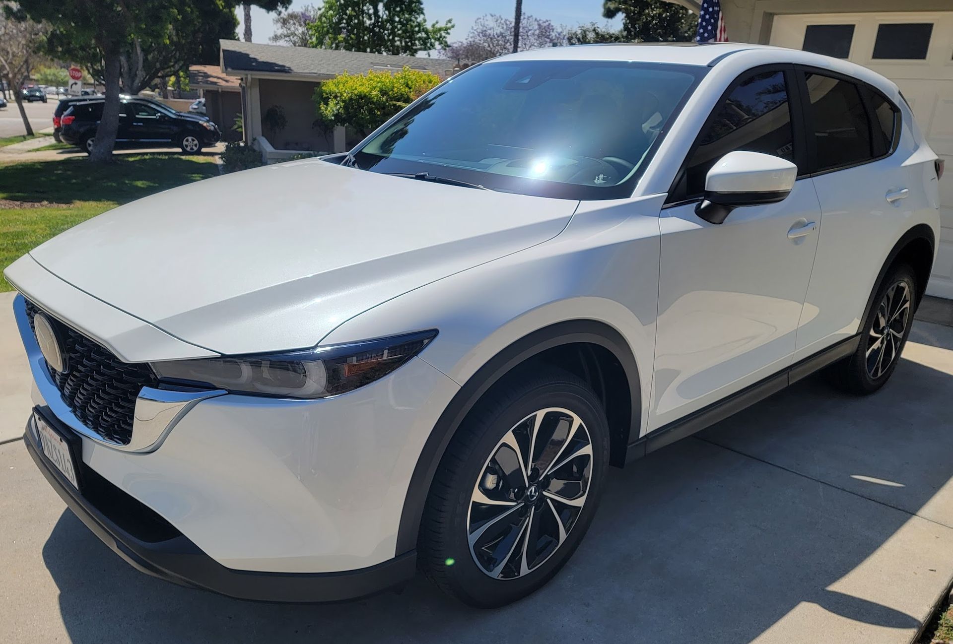 White Mazda CX-5 SUV parked on a driveway. Sunny day.