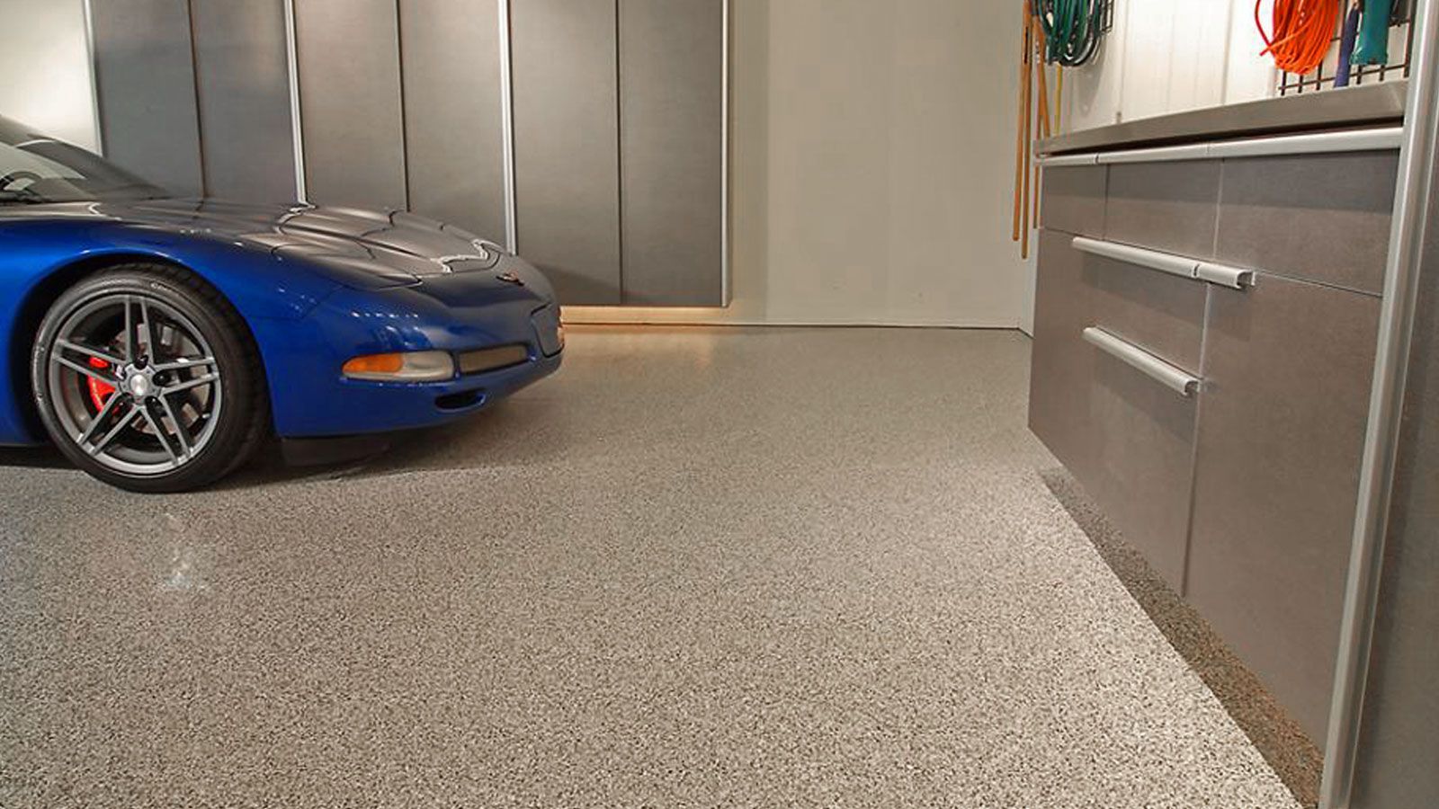 A blue sports car is parked in a garage.