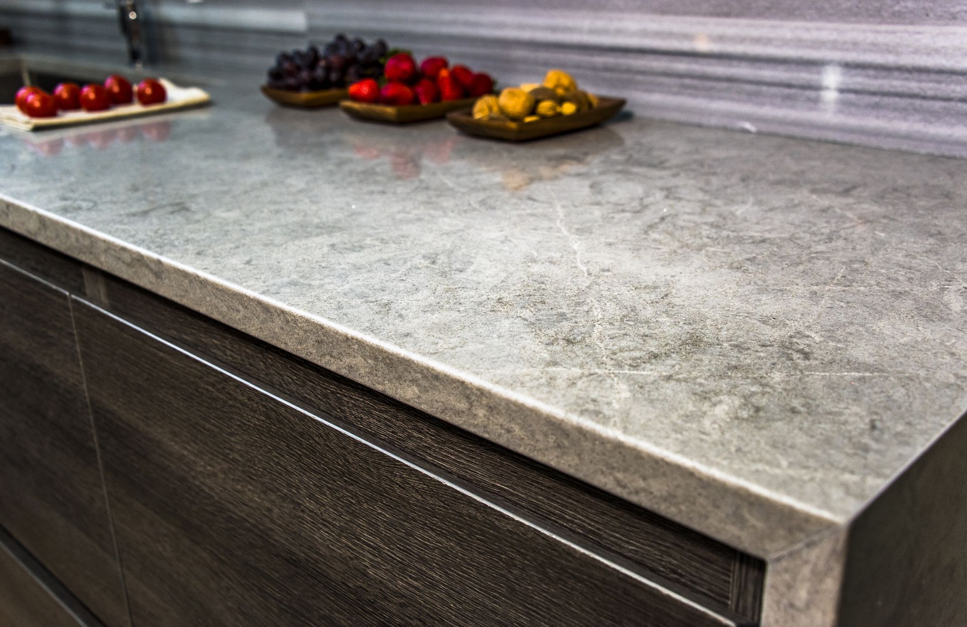 A kitchen counter with a bowl of fruit on it.