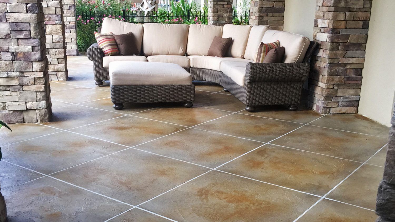 A patio with a sectional couch and ottoman