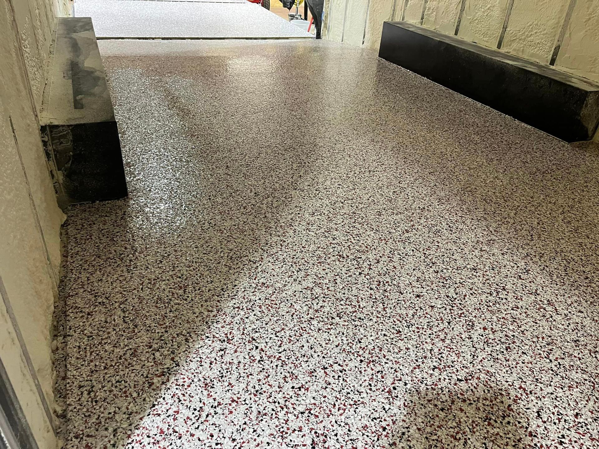 A close up of a concrete floor with a door in the background.