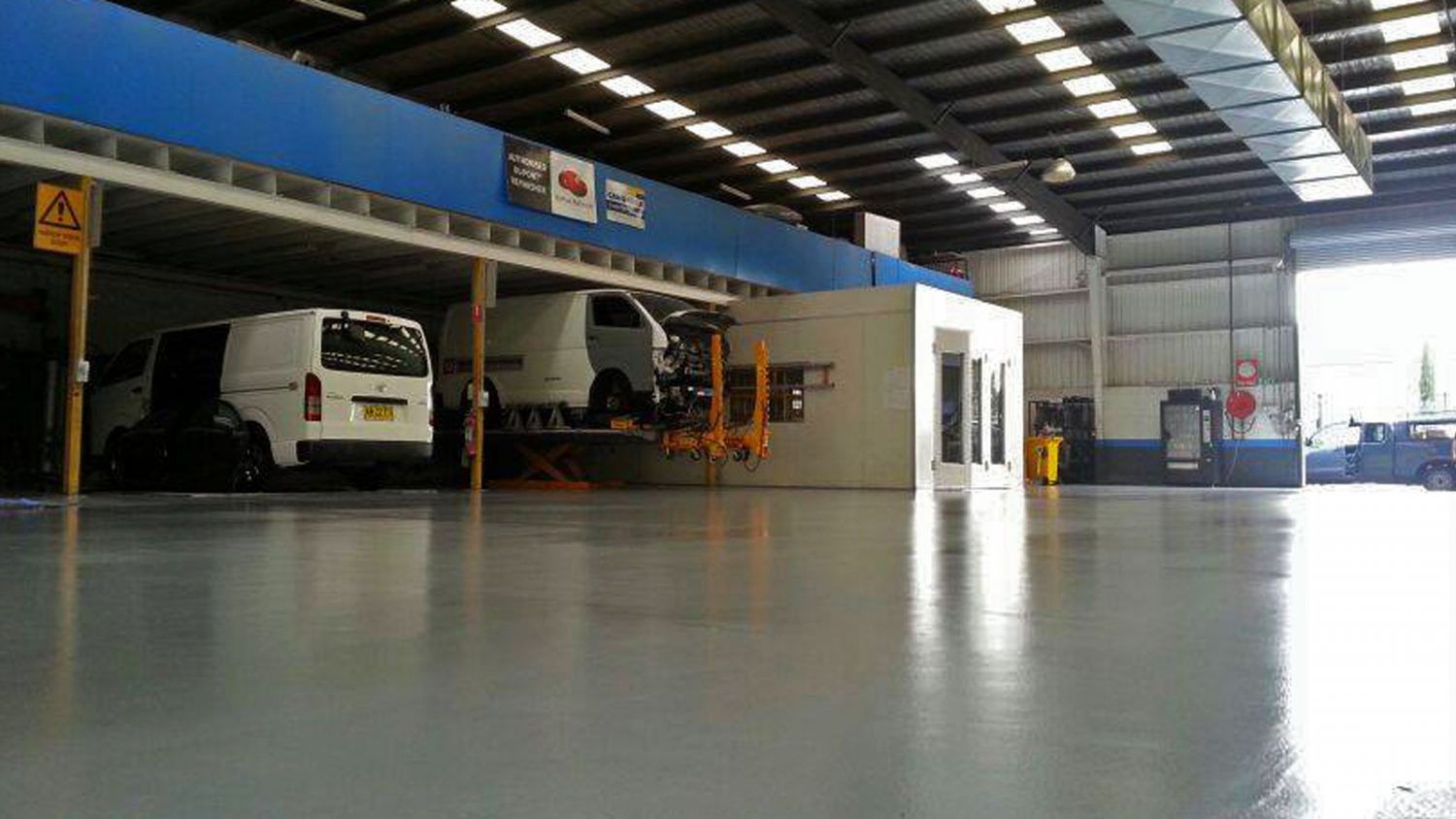 A warehouse with a lot of cars parked inside of it.