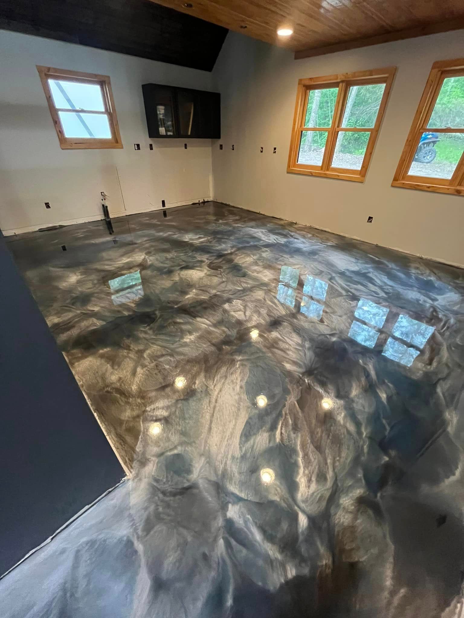 A room with a shiny metallic floor and a lot of windows.