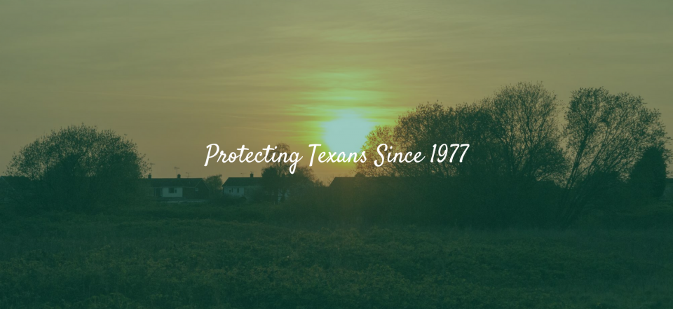 A sunset over a field and trees with the text