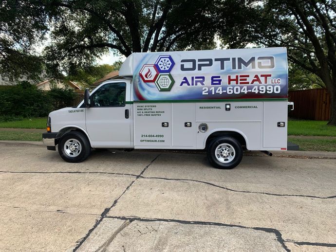 A white optima air and heat truck is parked on the side of the road.