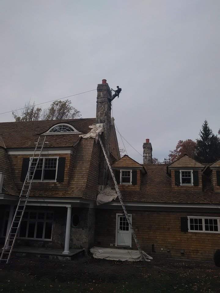 roof repair services Workers on top of house