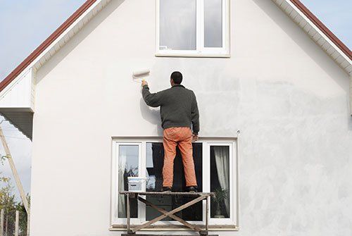 Worker is painting a wall