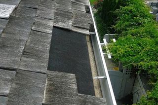 Man installing house roof rain gutter system